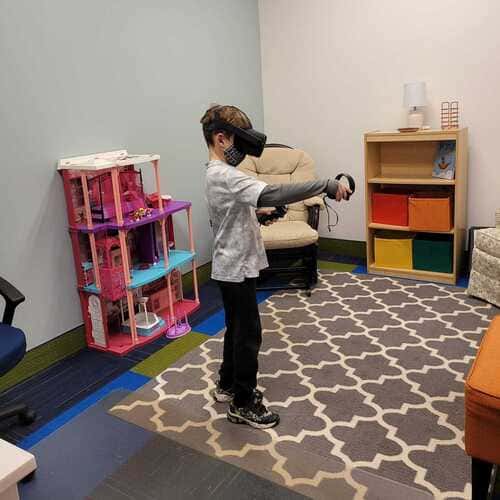 Boy playing with VR head set in the MindFit clinician office
