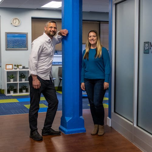 MindFit owners Dr Rob Rice and Julie Cenzi standing by a column in the MindFit office.